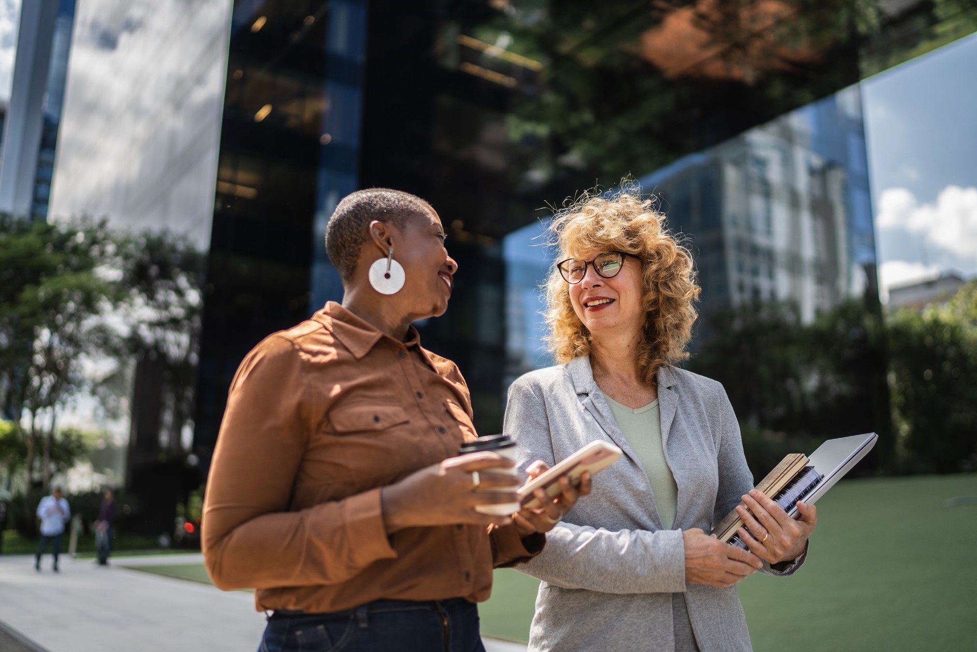Business women talking while walking outdoors